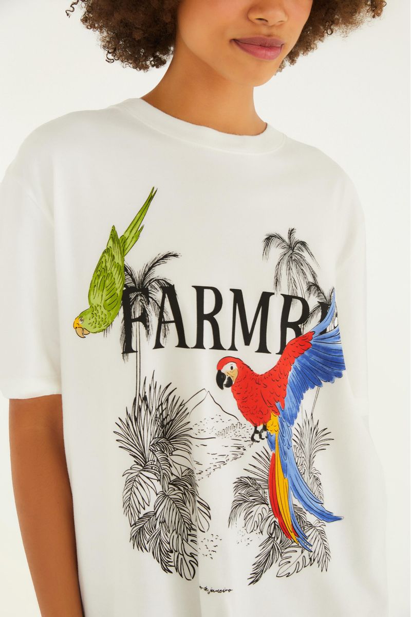 Detalle del estampado tropical con guacamayas y hojas en la camiseta.