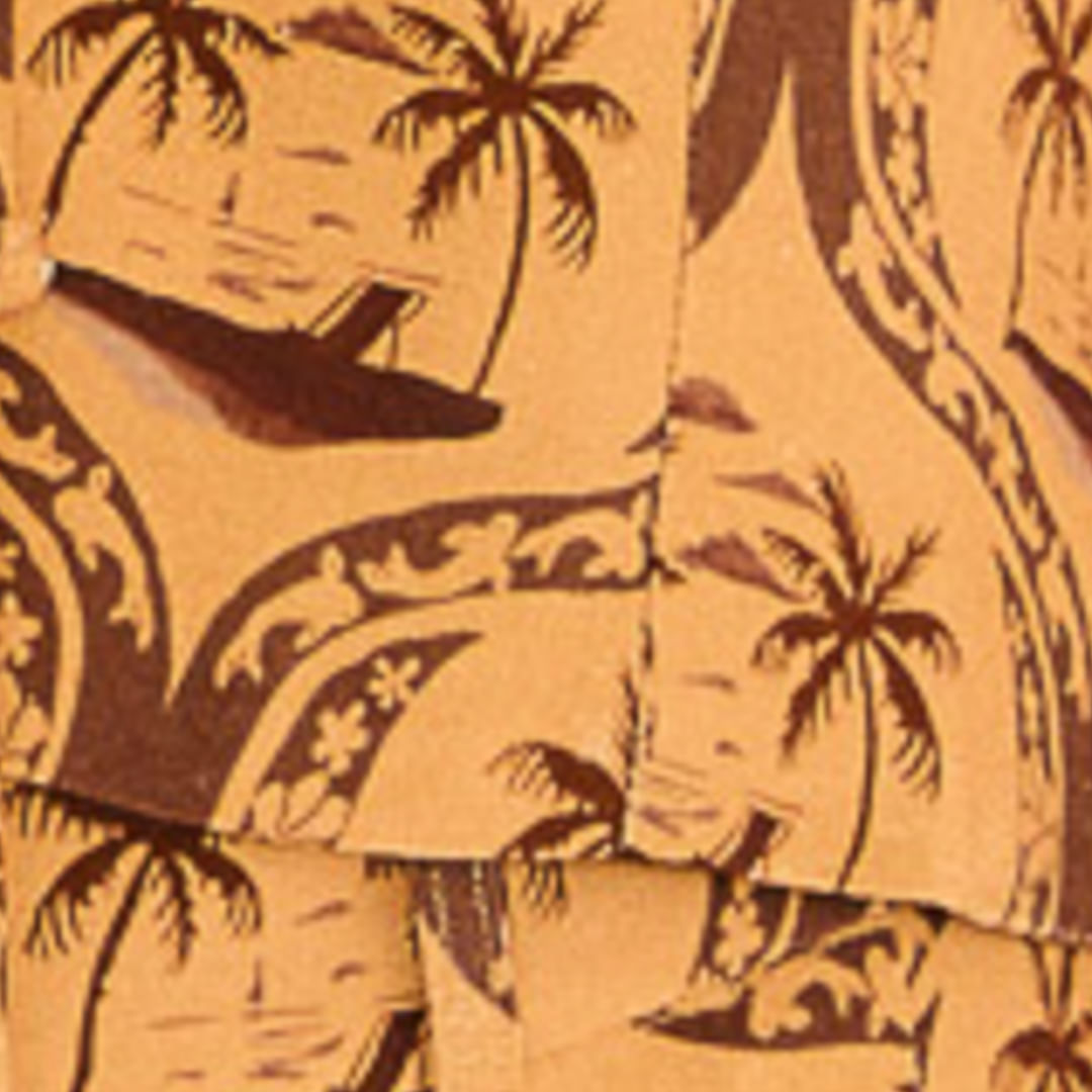 Detalle del estampado tropical con palmeras en tonos ocres y marrón.