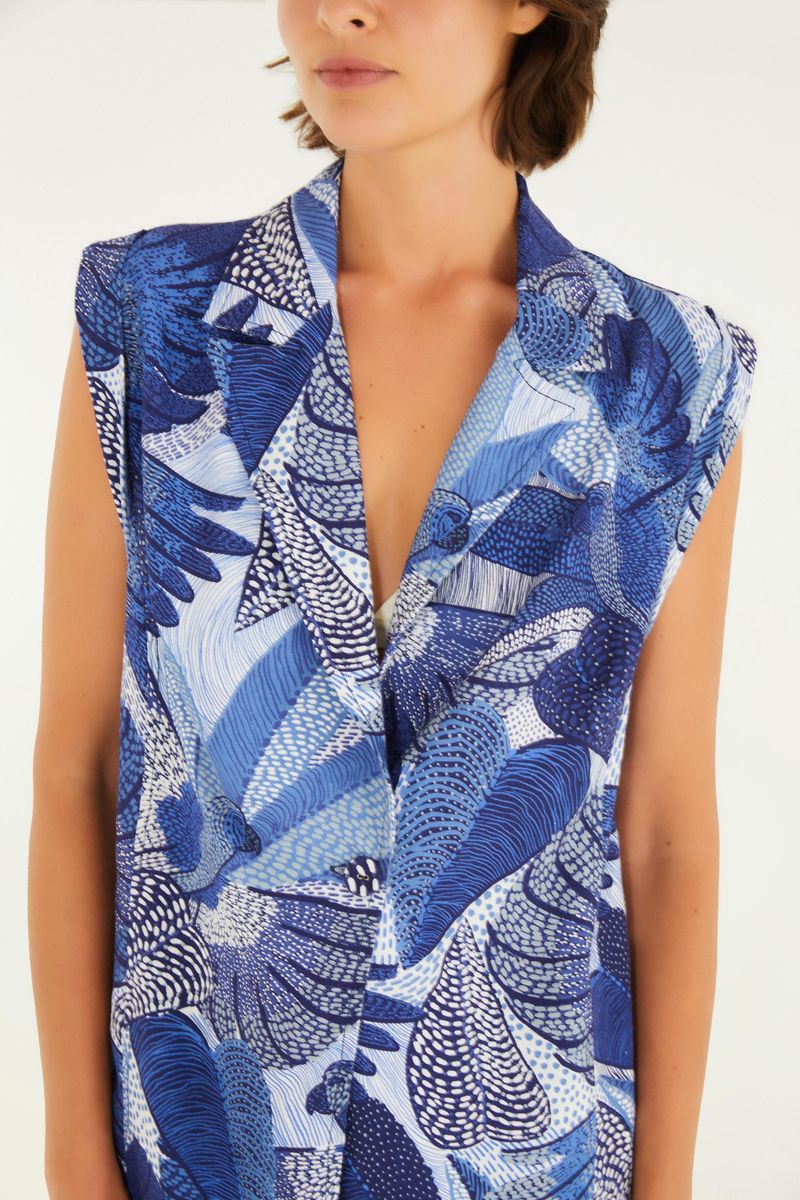 Detalle de la solapa y estampado del blazer sin mangas.
