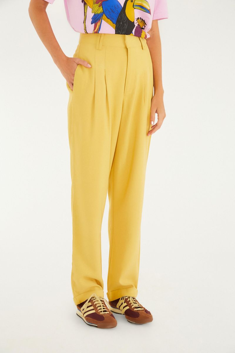 Detalle de la cintura alta y ajuste del pantalón zanahoria amarillo.