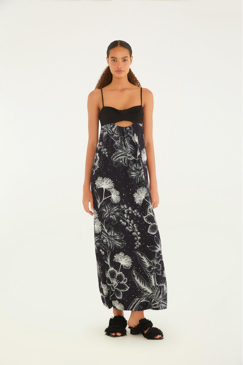 Imagen de un vestido largo con tirantes finos, estampado floral en tonos oscuros y detalle recortado en la parte delantera.