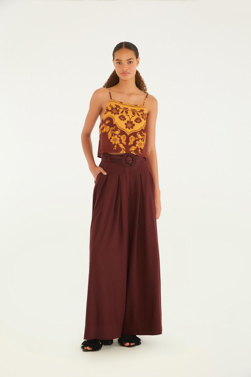 Imagen de un modelo vistiendo un pantalón palazzo marrón con pliegues, vista frontal.