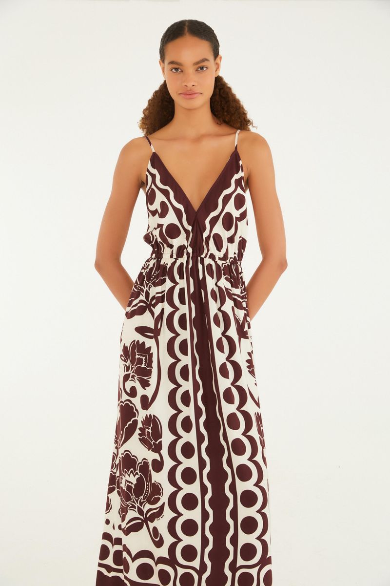 Vestido largo con tirantas finas y estampado floral arabesco en tonos marrón y blanco, visto de espaldas.