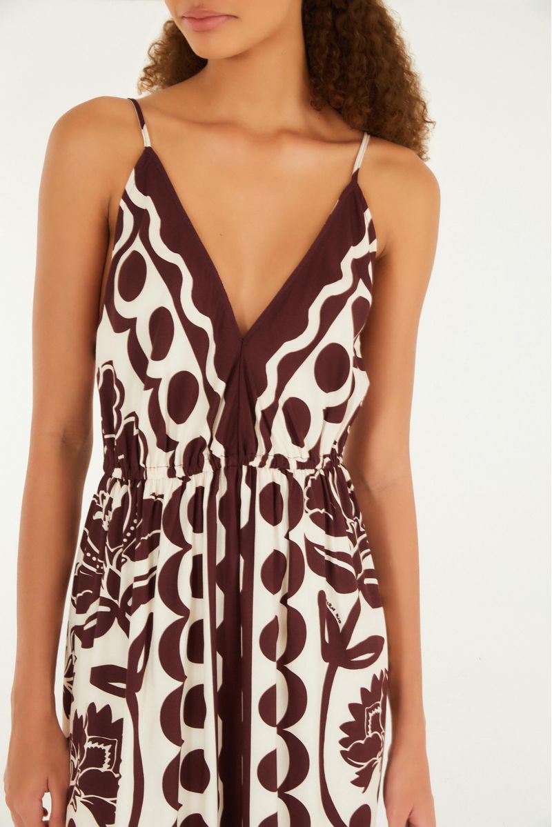 Detalle del escote en V del vestido largo con estampado floral arabesco en tonos marrón y blanco.