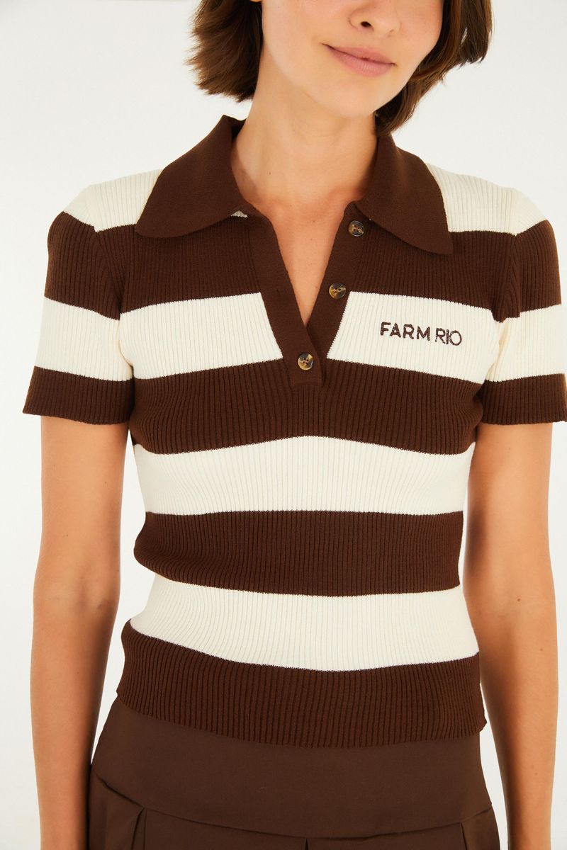 Detalle del cuello y logotipo de la camiseta polo rayada.
