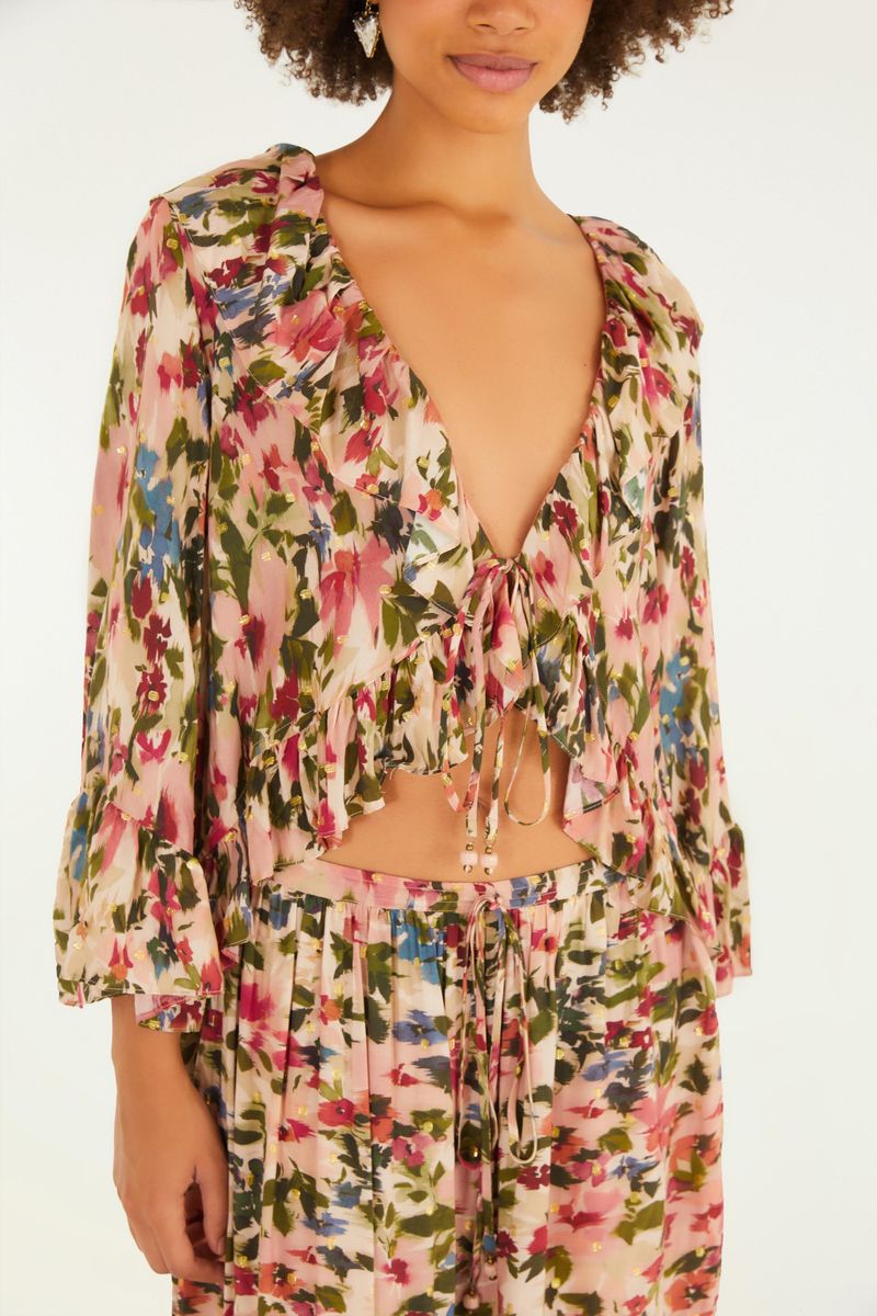 Imagen de una blusa estampada con escote en V y mangas abullonadas, vista de detalle frontal.