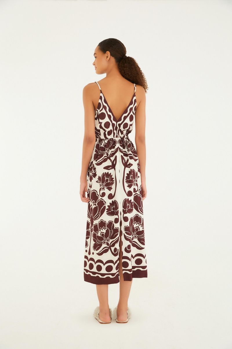 Vista lateral del vestido largo con tirantas finas y estampado floral arabesco en tonos marrón y blanco.
