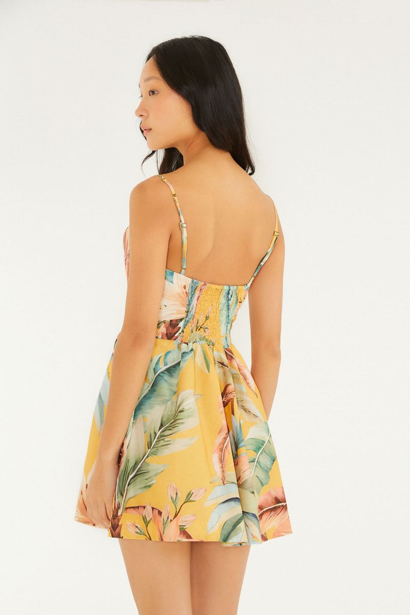 Imagen de un vestido corto con estampado tropical, mostrando la parte lateral y la caída suelta.