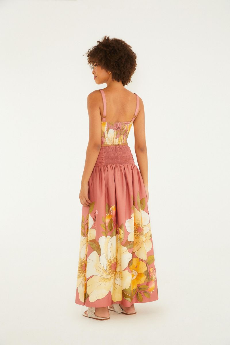 Modelo usando una falda corta con estampado floral localizado, vista trasera.