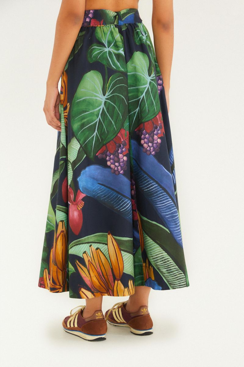 Vista trasera de la falda larga estampada con elementos tropicales y fondo azul oscuro.