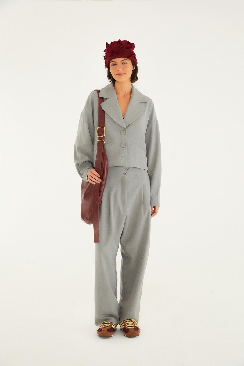 Conjunto de blazer y pantalón de alta costura en mezcla gris, con bolso y zapatos, visto de cuerpo entero.