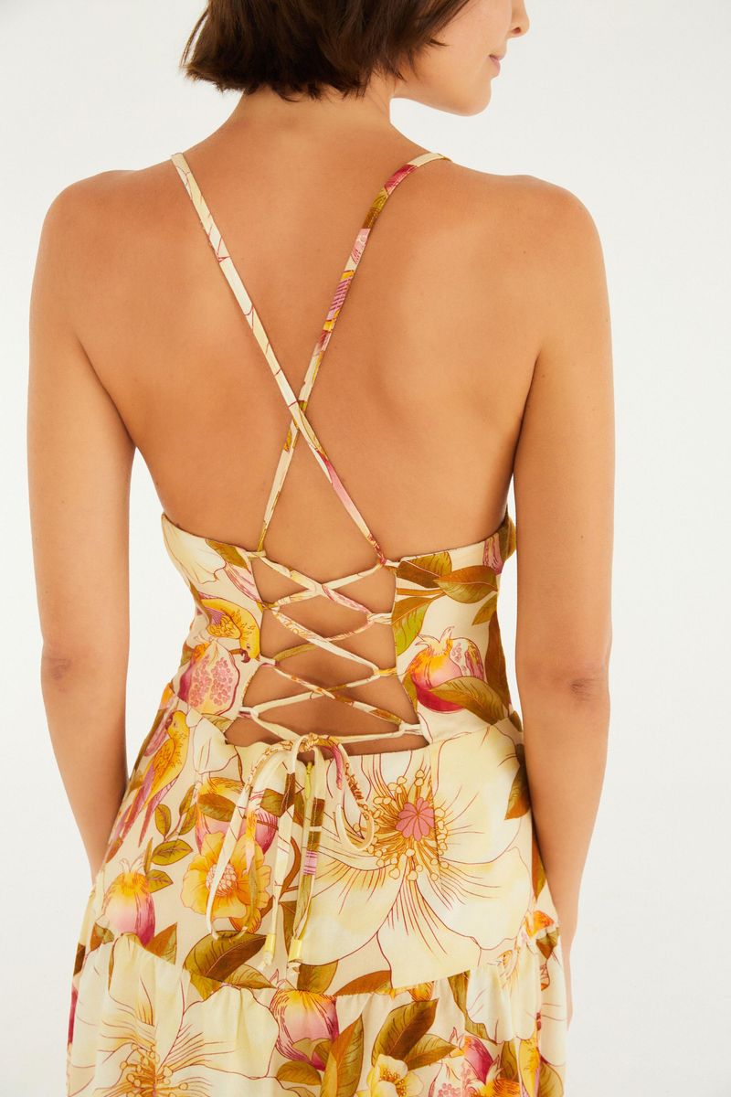 Primer plano de la espalda de un vestido corto con estampado floral, mostrando detalles cruzados.