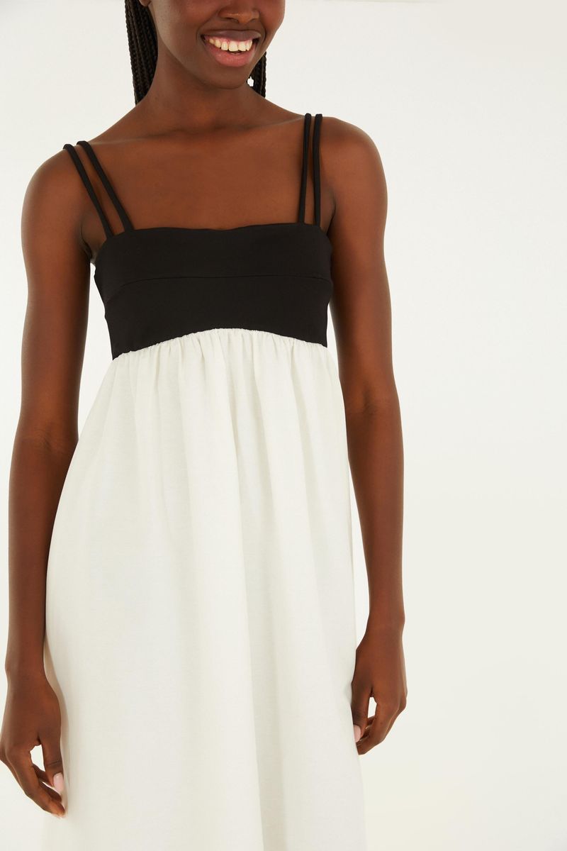 Imagen de una modelo llevando un vestido bicolor con tirantes, vista frontal detallada.