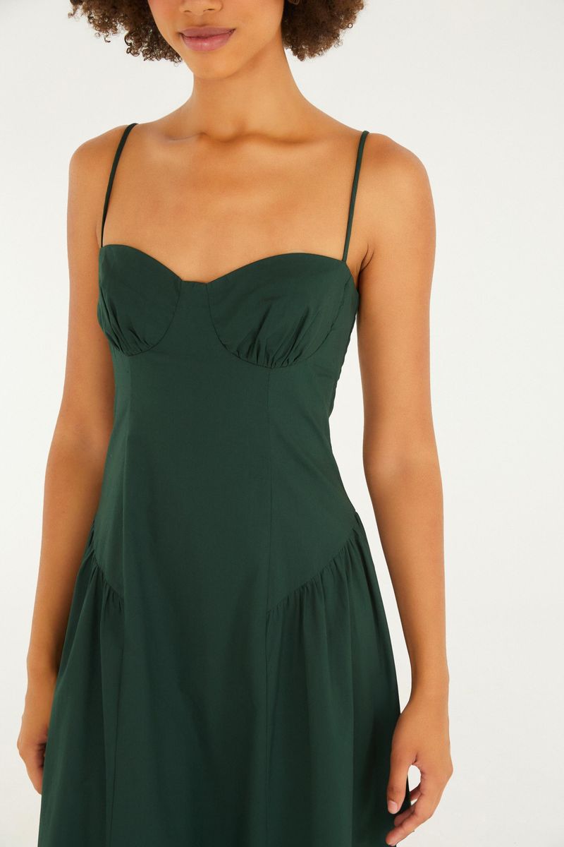 Imagen mostrando un vestido largo verde con tiras finas y corsé, visto desde atrás.