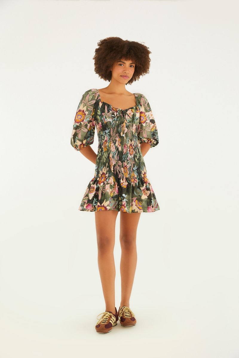 Vestido corto floral con detalles de volantes en el borde, presentado en vista completa.