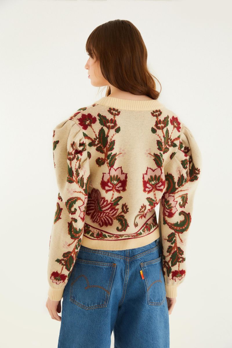 Vista trasera del cardigan corto de tricot con estampado floral, mostrando el panel detallado trasero y las mangas abullonadas.