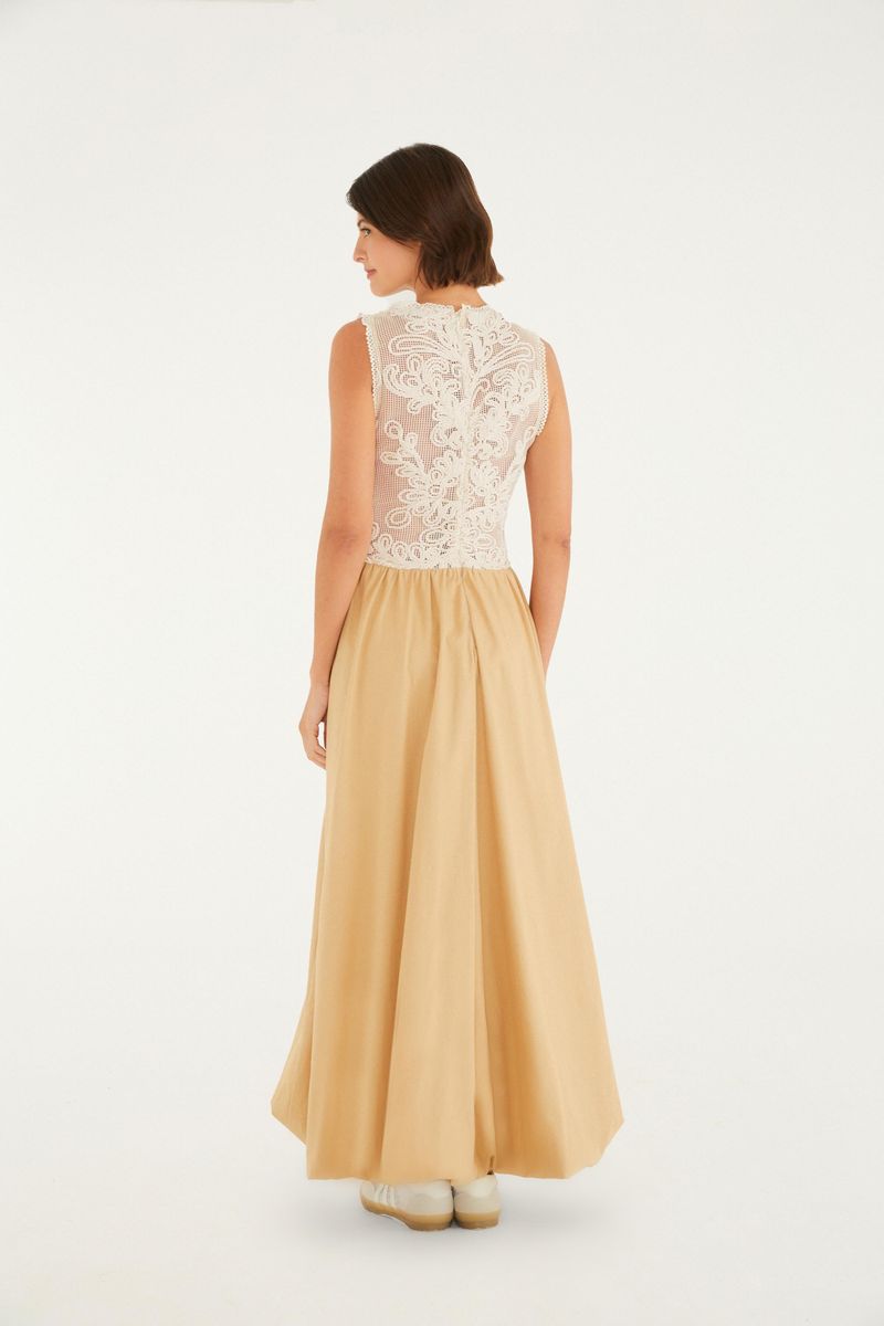 Vista lateral del vestido largo con corsé de encaje blanco y falda fluida beige.
