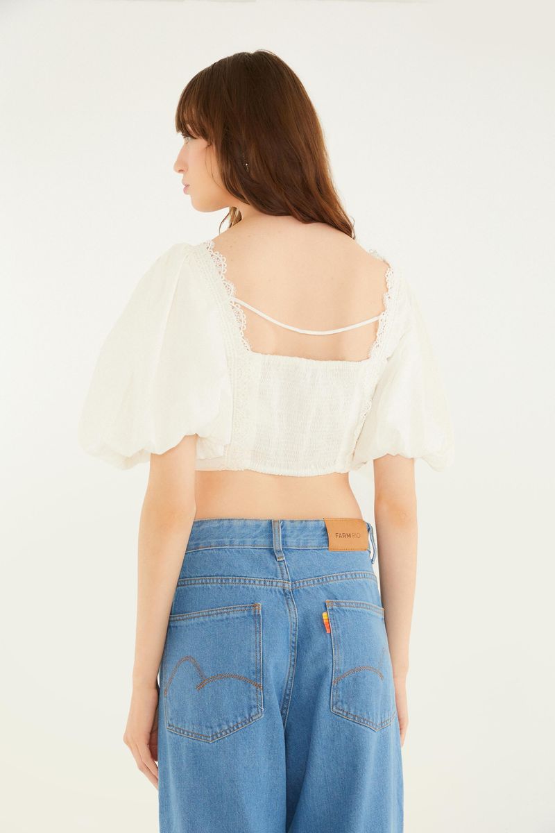 Vista trasera de la blusa artesanal romántica con tirantes delgados y mangas abullonadas.
