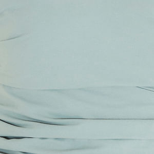 Close-up de la tela y los volantes de la blusa, mostrando la textura y calidad.