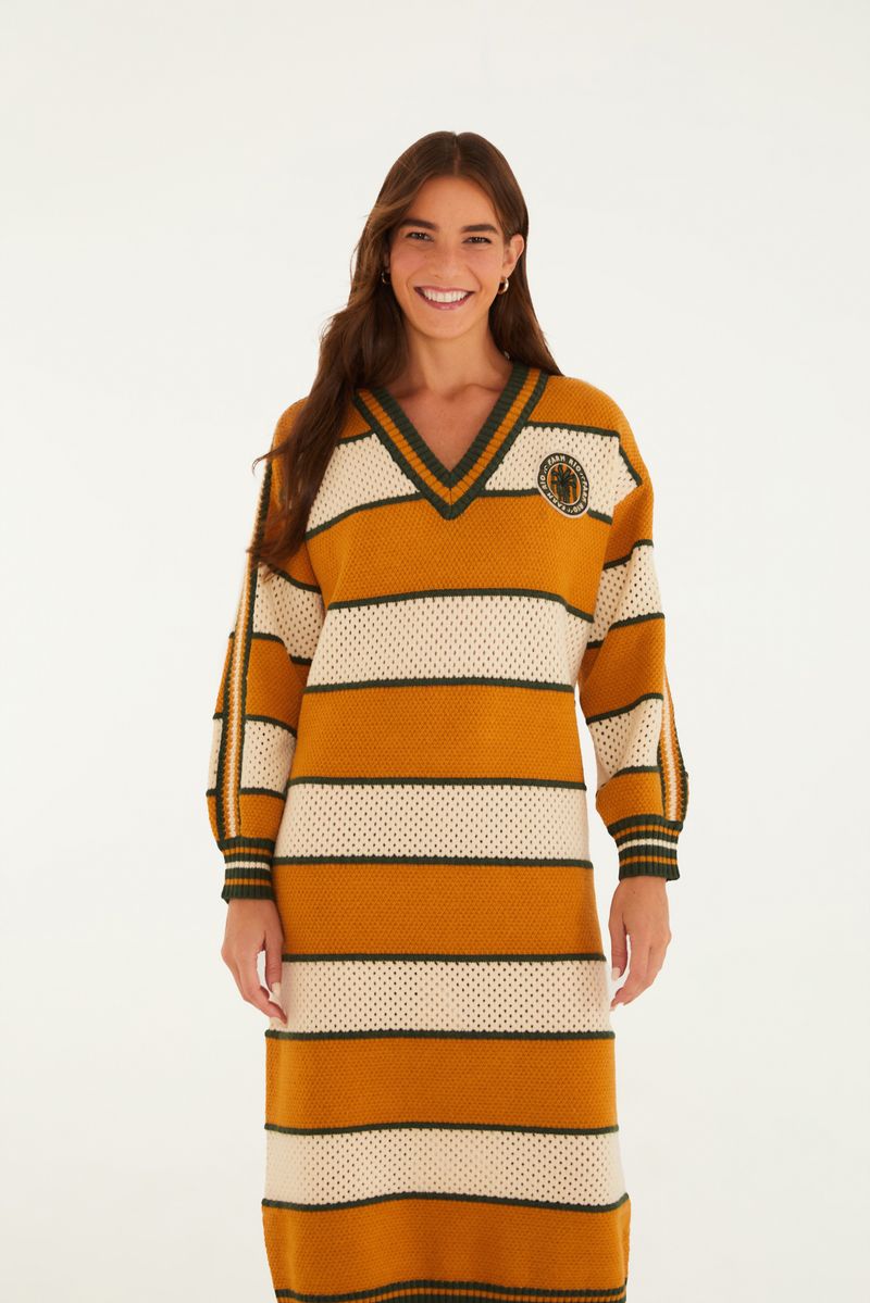 Vestido de tejido de punto con rayas horizontales en tonos amarillo y blanco, con detalles en verde y un emblema bordado en el pecho.