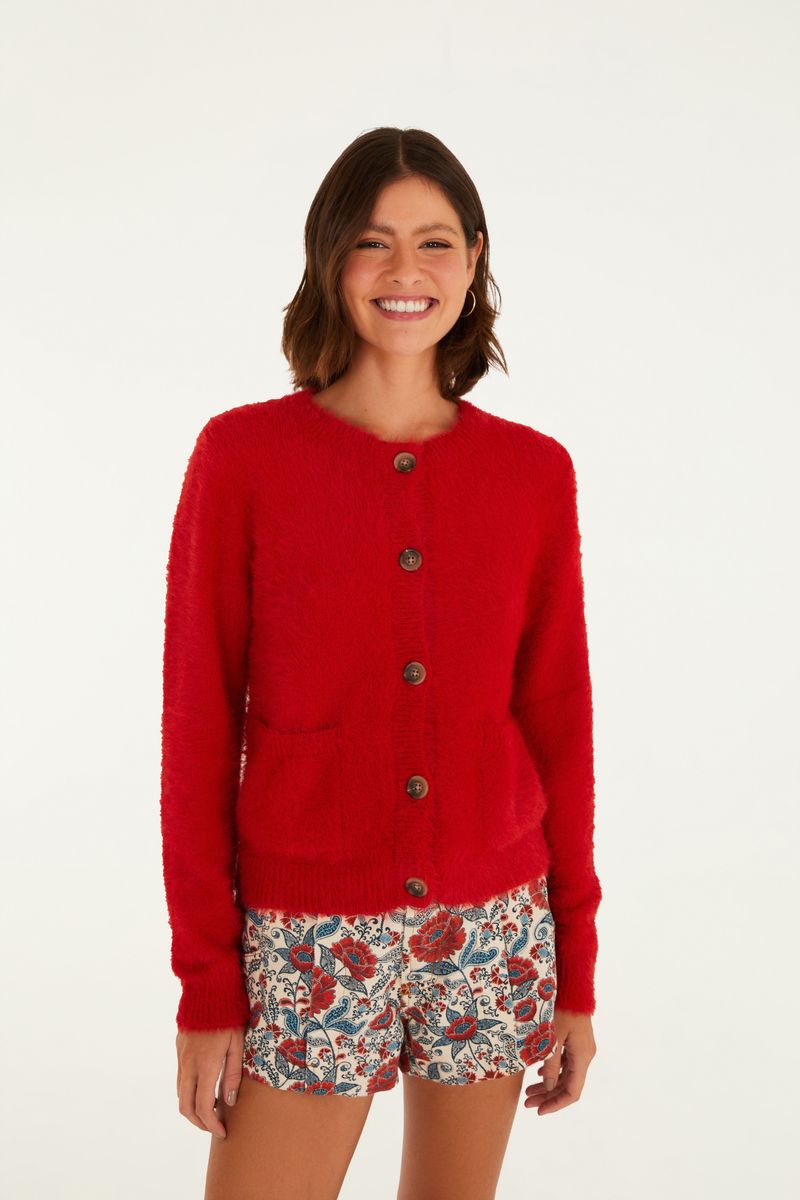Cardigan corto de color rojo con textura de pelito, visto desde el frente, combinado con shorts estampados.