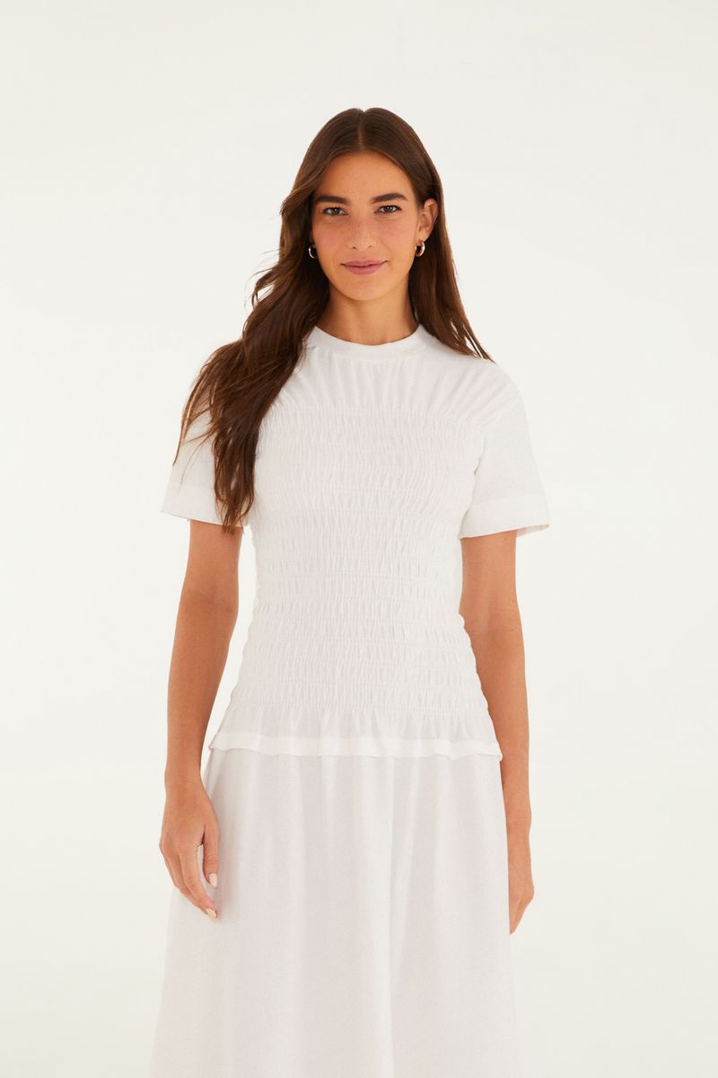 Vista frontal del vestido blanco con detalles de abertura y ajuste en la cintura.
