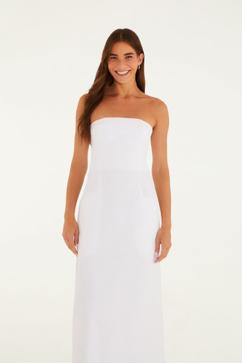 Imagen de un vestido recto de sastre blanco, sin tirantes, de longitud larga, visto de lado.