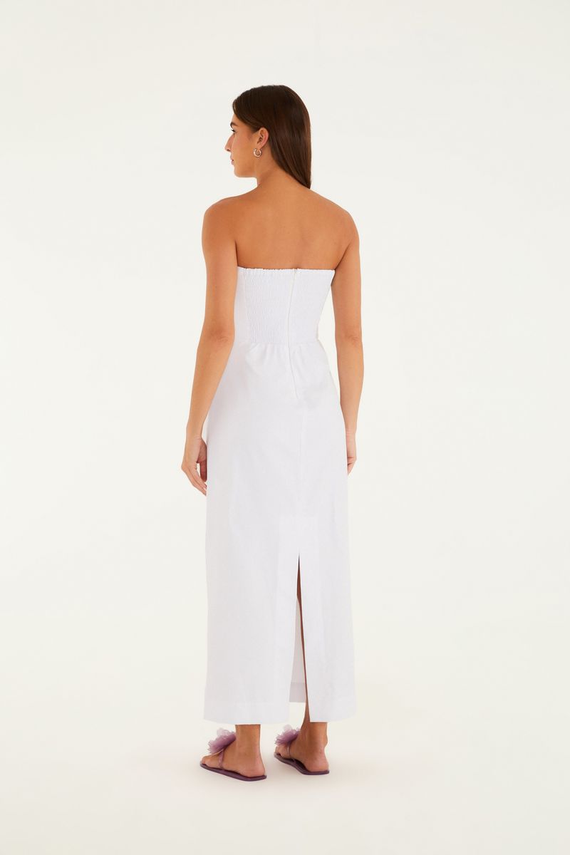 Imagen de un vestido recto de sastre blanco, sin tirantes, de longitud larga, visto desde la parte trasera con abertura.