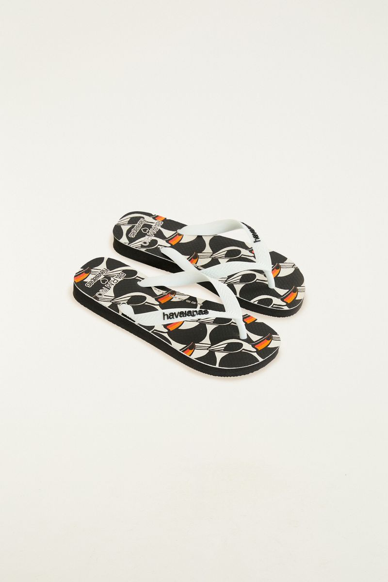 Sandalias Havaianas Copatucano con estampado de tucanes sobre fondo negro, correas blancas y suela de caucho vistas de lado.
