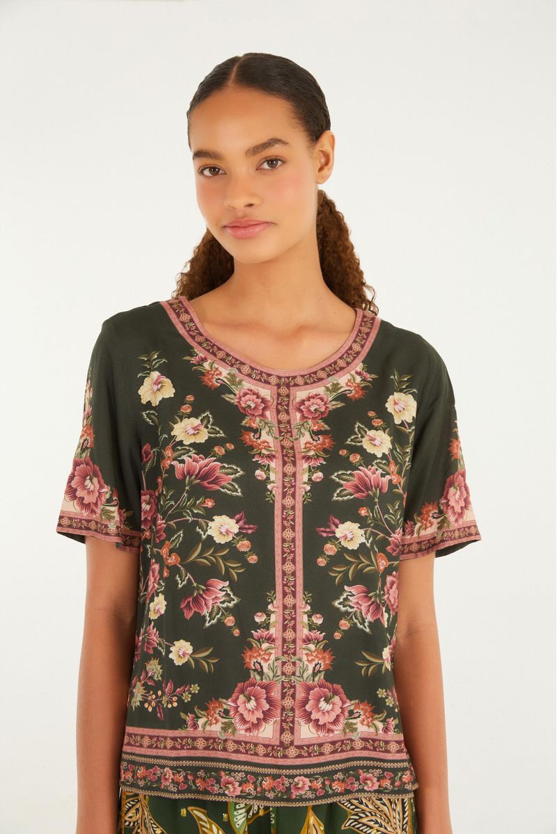 Camiseta Lina con estampado floral vista de frente, destacando el diseño simétrico y el fondo verde oscuro.