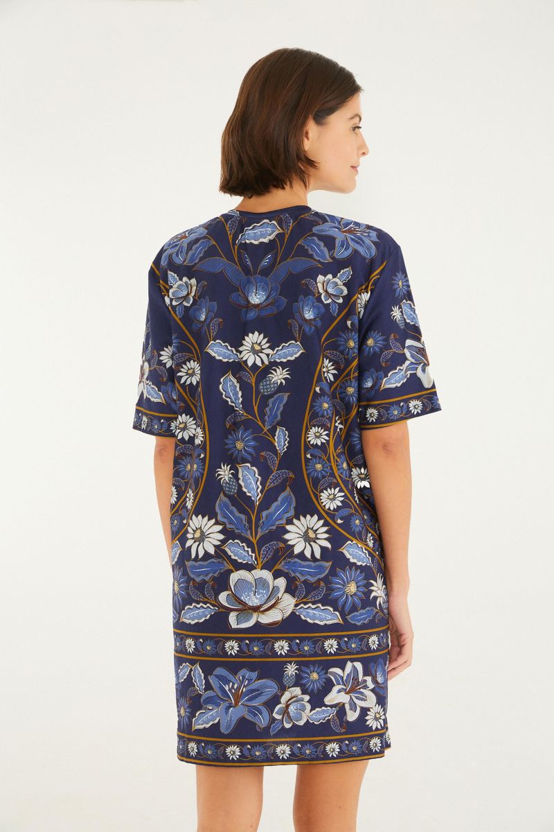 Vestido tipo camiseta con estampado floral azul y blanco, visto desde la espalda.