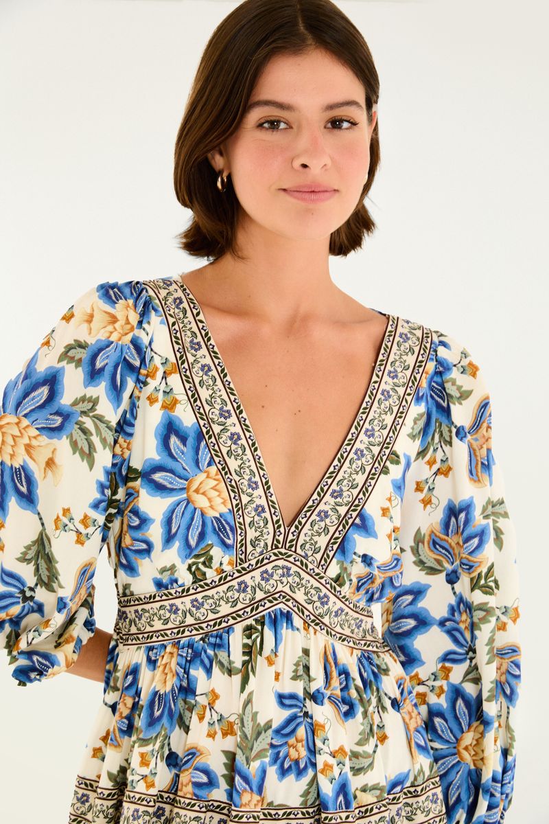 Detalle del escote profundo en forma de V del vestido con estampado floral y bordado decorativo.
