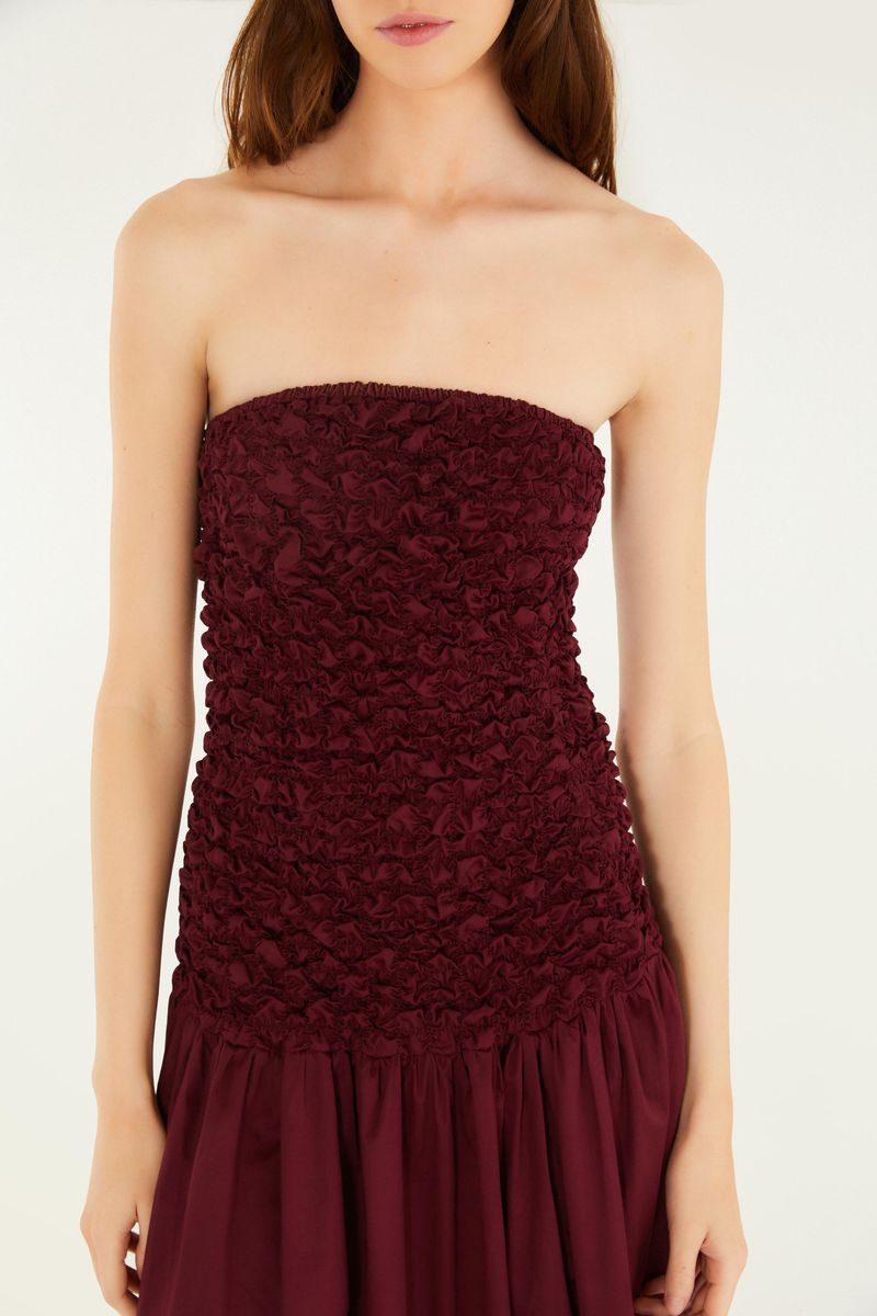 Close-up del corpiño del vestido mostrando el detalle de lastex en tono vino.