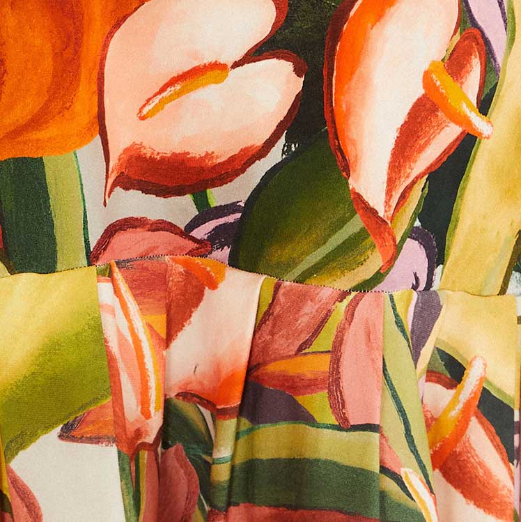 Imagen mostrando un detalle del estampado del vestido con motivos de follaje y flores en colores vibrantes.
