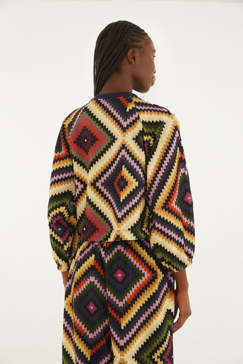 Chaqueta estilo bomber con estampado geométrico vibrante, vista trasera.