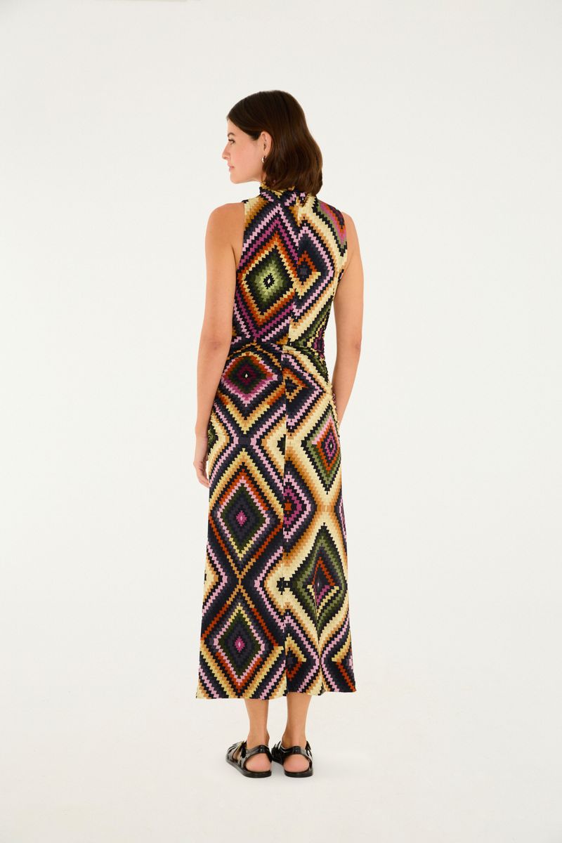 Vestido midi estampado con diseño geométrico en colores vibrantes, visto de perfil.