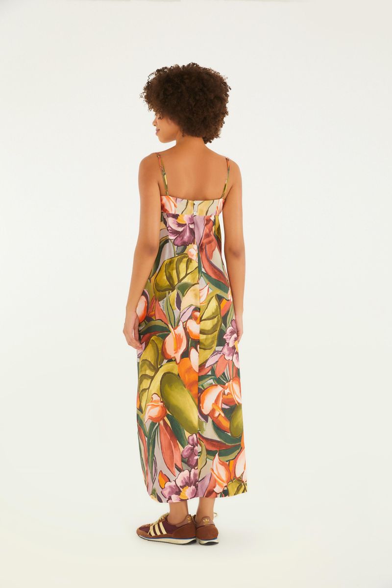 Imagen trasera de un vestido largo con tirantes delgados y estampado de follaje tropical, mostrando la caída y diseño.