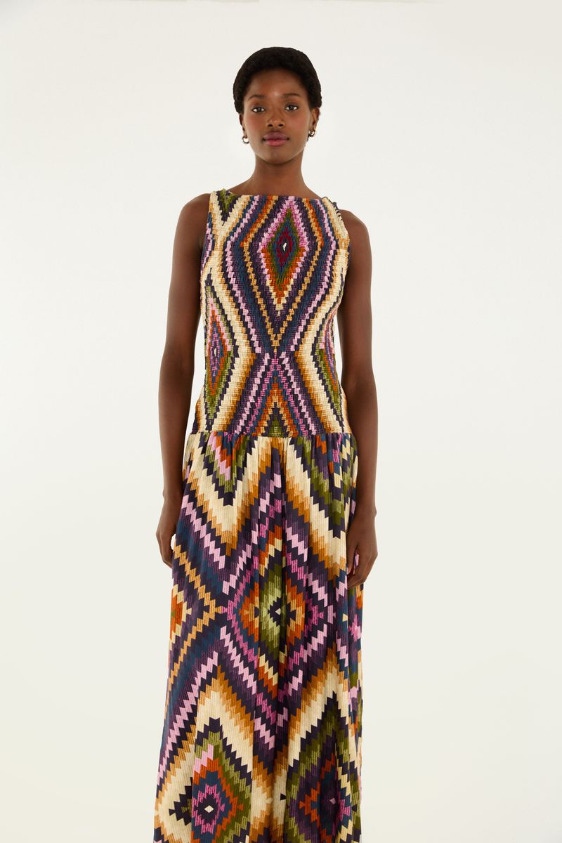 Vestido largo con estampado geométrico en colores vibrantes, visto de espaldas.