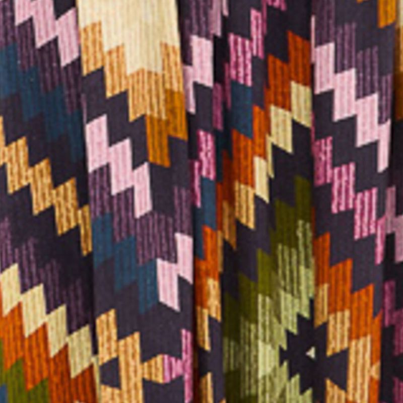 Primer plano del estampado geométrico del vestido largo, mostrando detalles de colores y texturas.