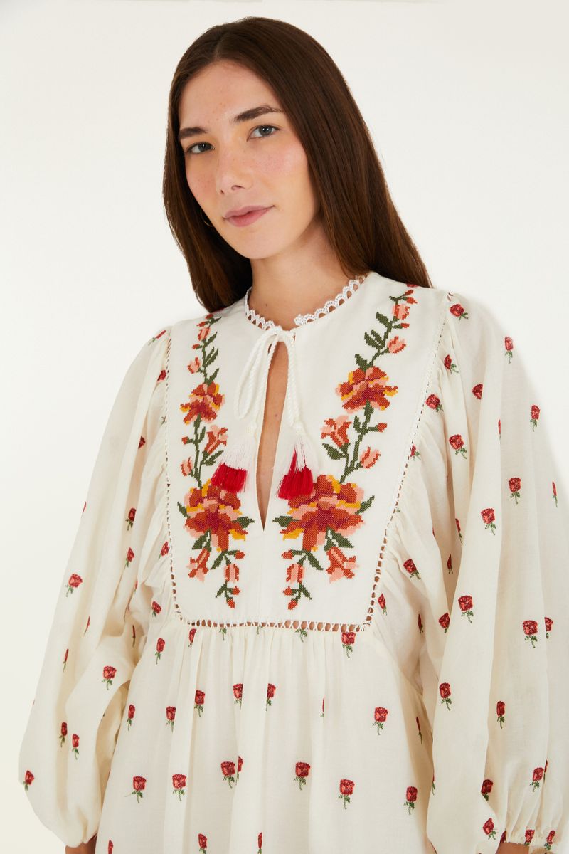Vestido bata artesanal bordado con estampado floral en fondo claro, vista trasera completa.