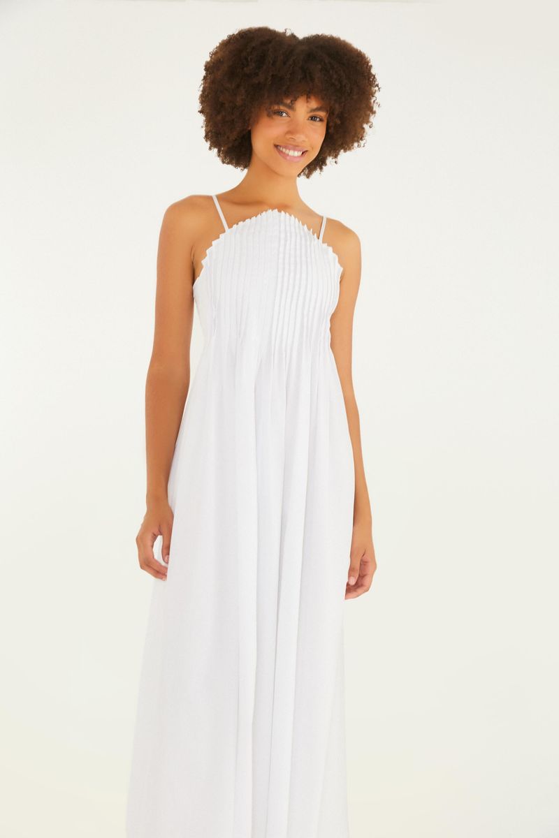 Imagen de un vestido blanco largo con pliegues al frente, tirantes delgados y estilo fluido, mostrado en una modelo de frente.