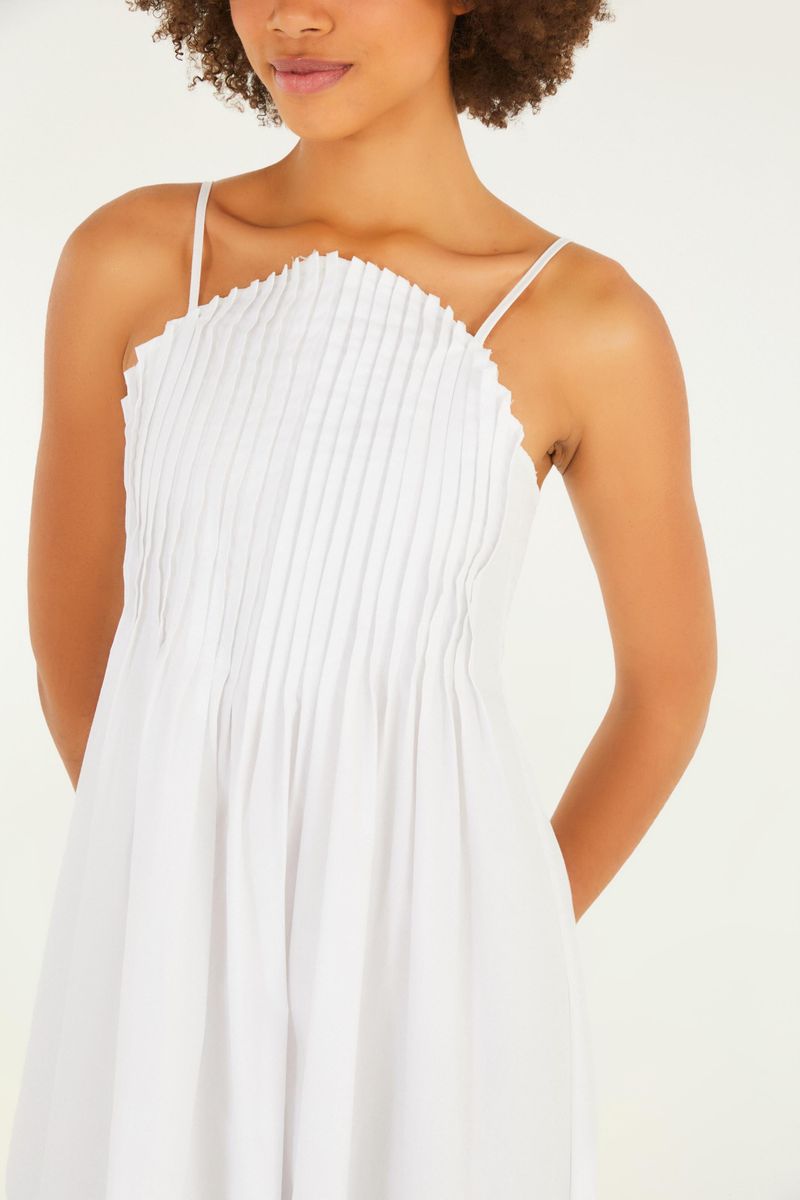 Imagen de un vestido blanco largo con pliegues al frente, tirantes delgados y estilo fluido, mostrado en una modelo de espaldas.