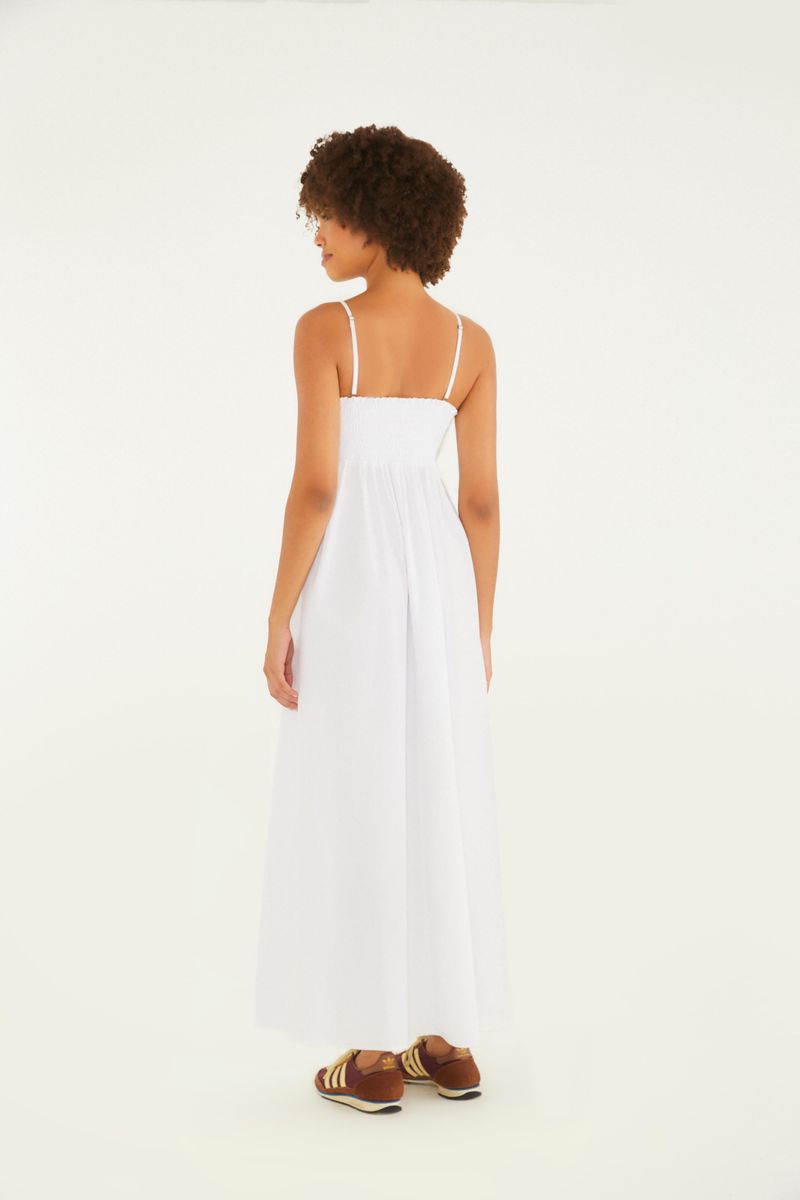 Imagen de un vestido blanco largo con pliegues al frente, tirantes delgados y estilo fluido, mostrando un detalle del corpiño con pliegues.