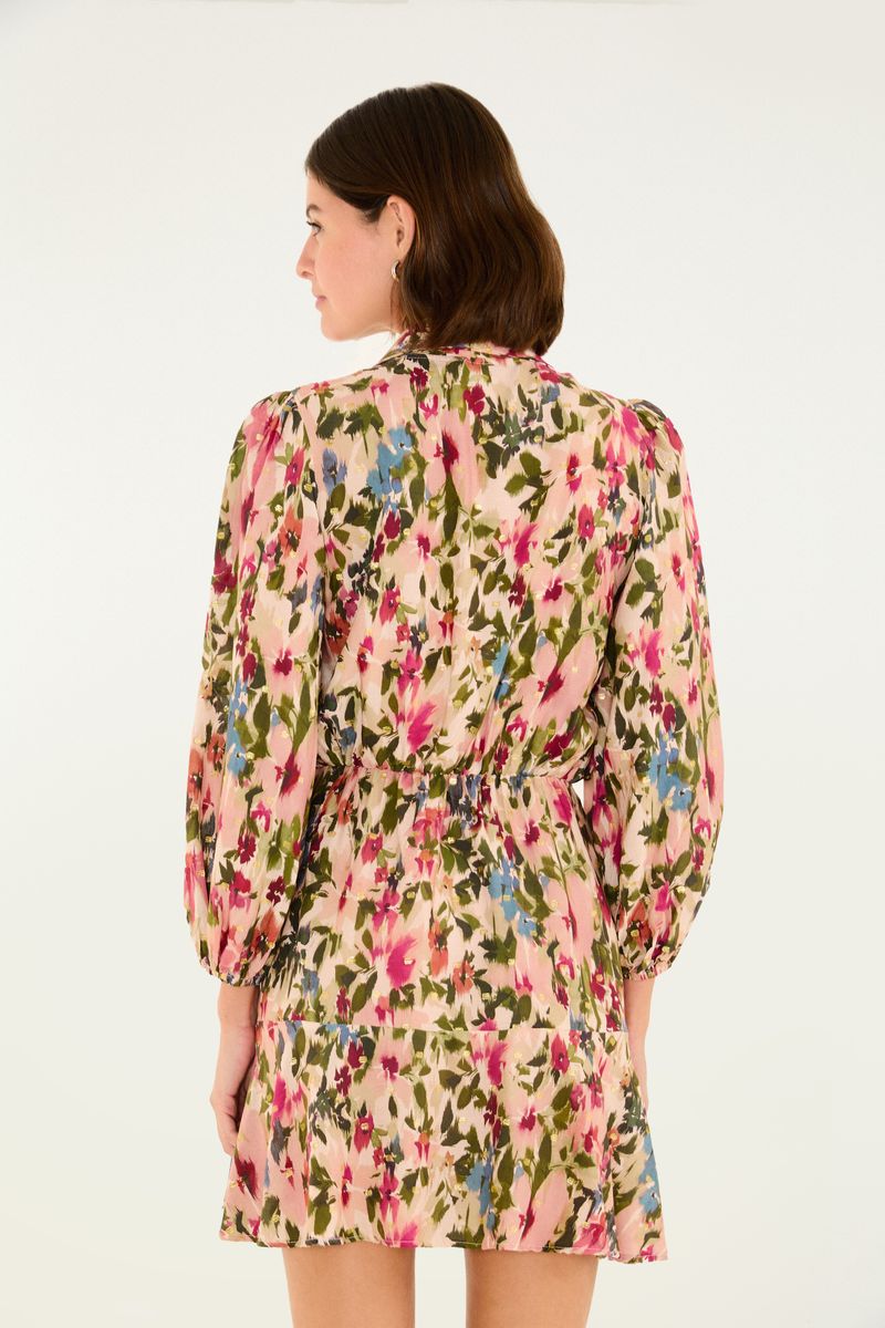 Vista lateral del vestido corto con estampado, mostrando el ajuste en la cintura y el patrón floral.