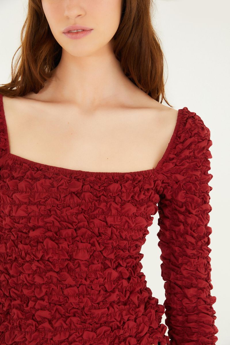 Detalle del escote en U de la Blusa Lastex Mangas, mostrando el acabado.