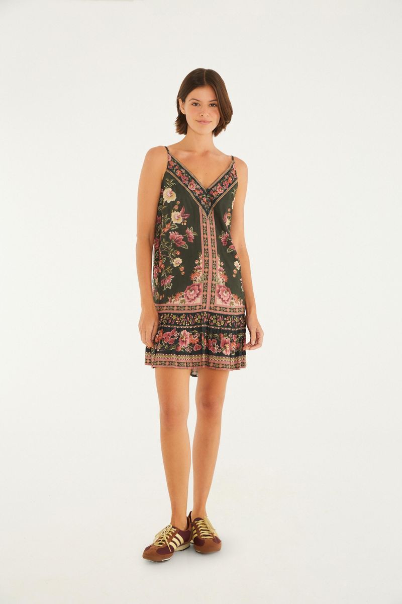 Vestido corto con estampado floral sobre fondo verde, tirantes finos y escote en V, visto desde atrás.