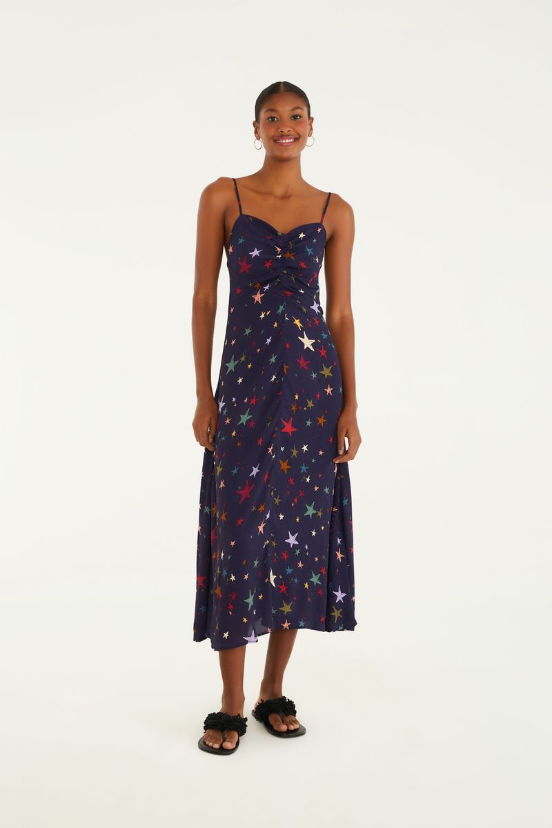 Vestido largo con tirantes y estampado de estrellas multicolores, visto de frente.
