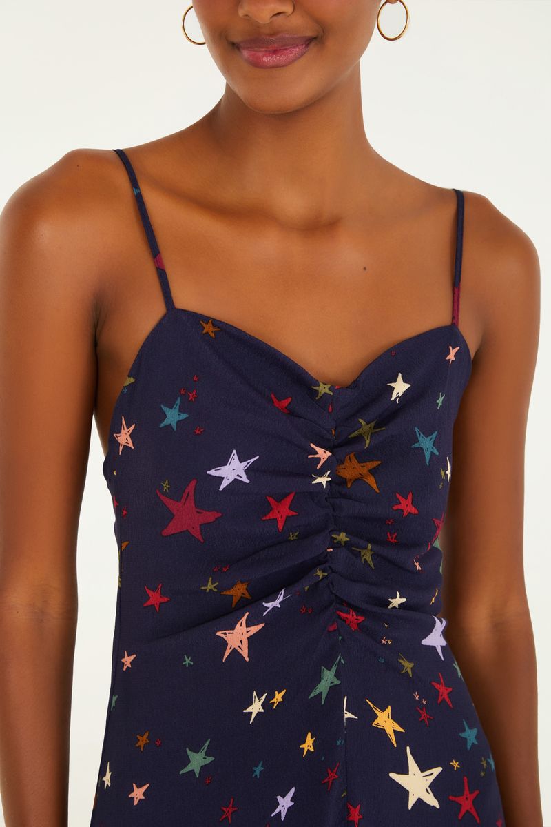 Detalle del corpiño del vestido con tirantes y estampado de estrellas multicolores.
