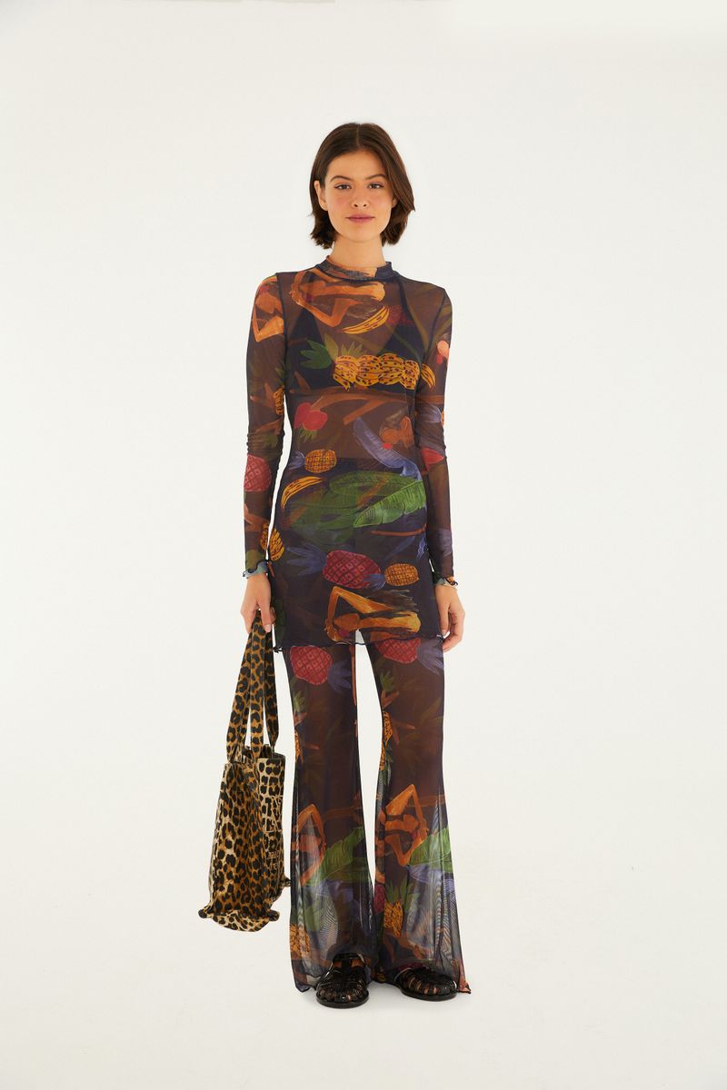 Modelo usando pantalón acampanado estampado con blusa a juego, sosteniendo un bolso de animal print.
