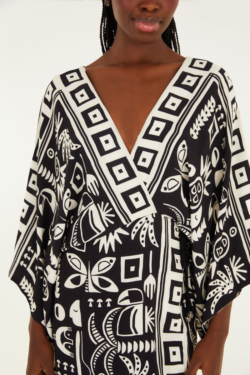 Detalle del escote en V del vestido corto con estampado tropical en blanco y negro.